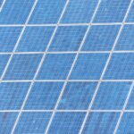 Pannelli fotovoltaici puliti che brillano al sole, simbolo di maggiore rendimento estivo.