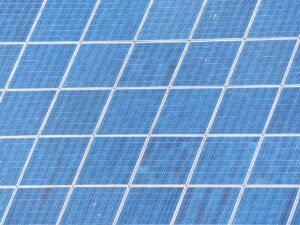 Pannelli fotovoltaici puliti che brillano al sole, simbolo di maggiore rendimento estivo.